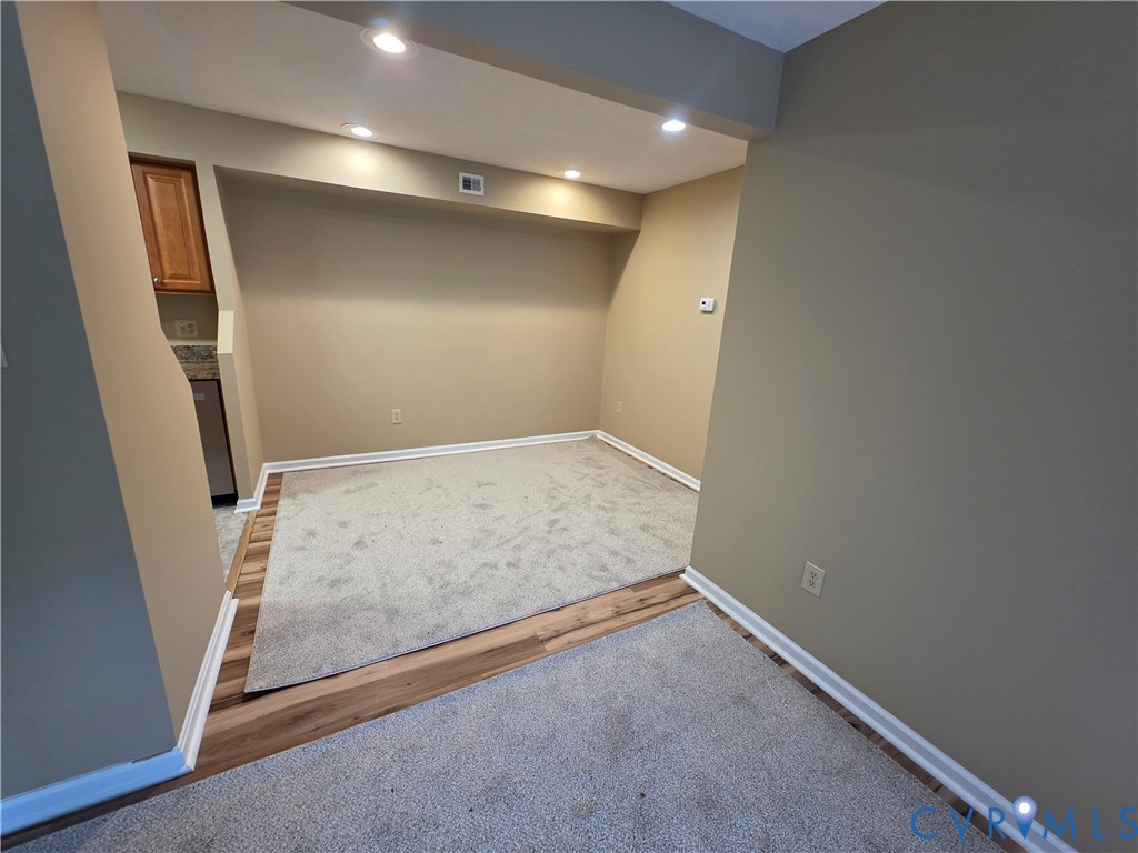 4003 Governors Square, Unit 8 Williamsburg, VA 23188 - Photo 5 of 27 an empty room with wooden floor and staircase