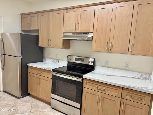 a kitchen with granite countertop white cabinets and stainless steel appliances