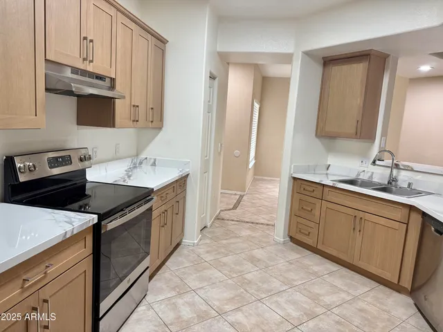 a kitchen with granite countertop a sink stove and cabinets
