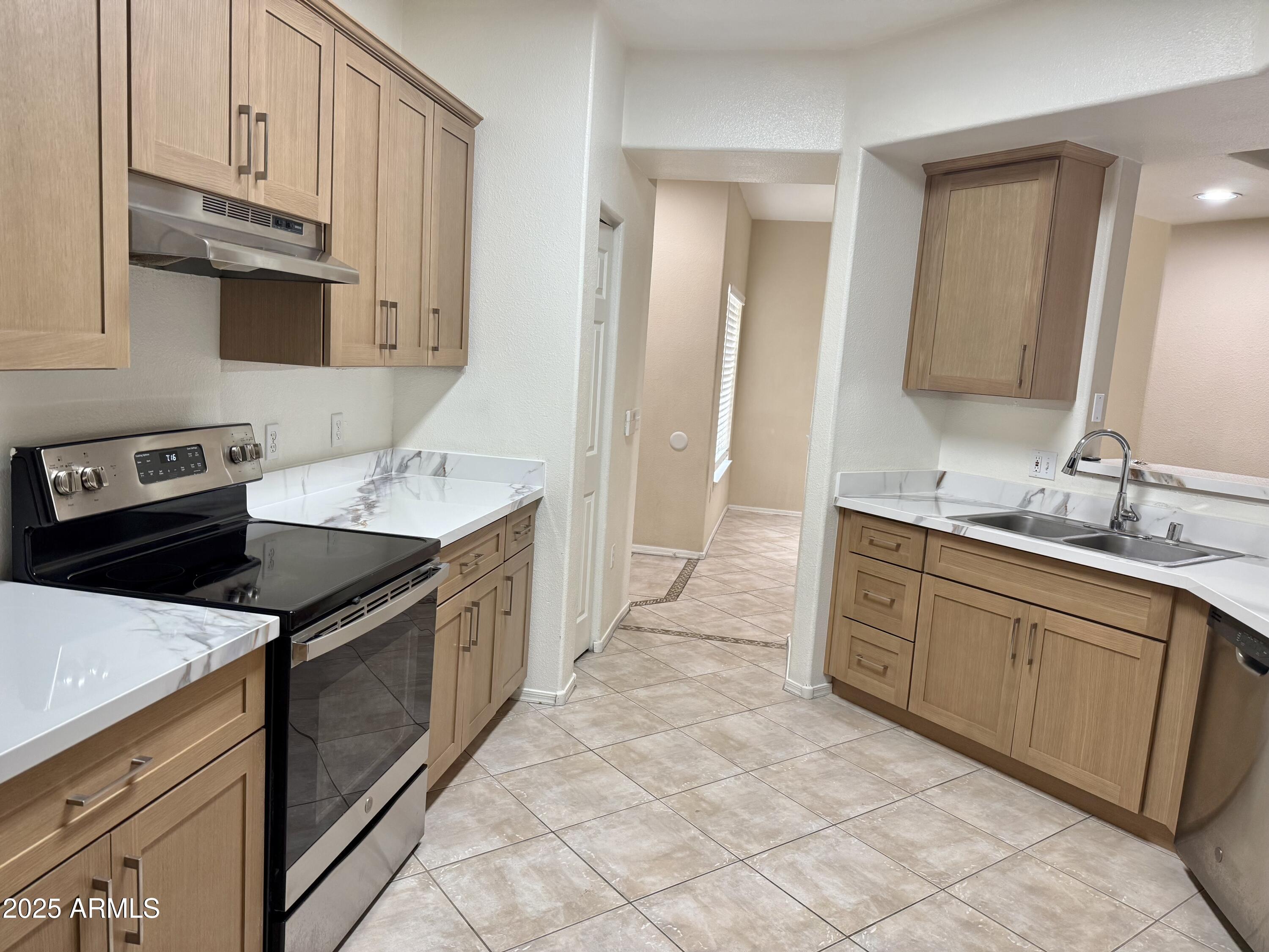 3236 East Chandler Boulevard, Unit 1071 Phoenix, AZ 85048 - Photo 17 of 35 a kitchen with granite countertop a sink stove and cabinets