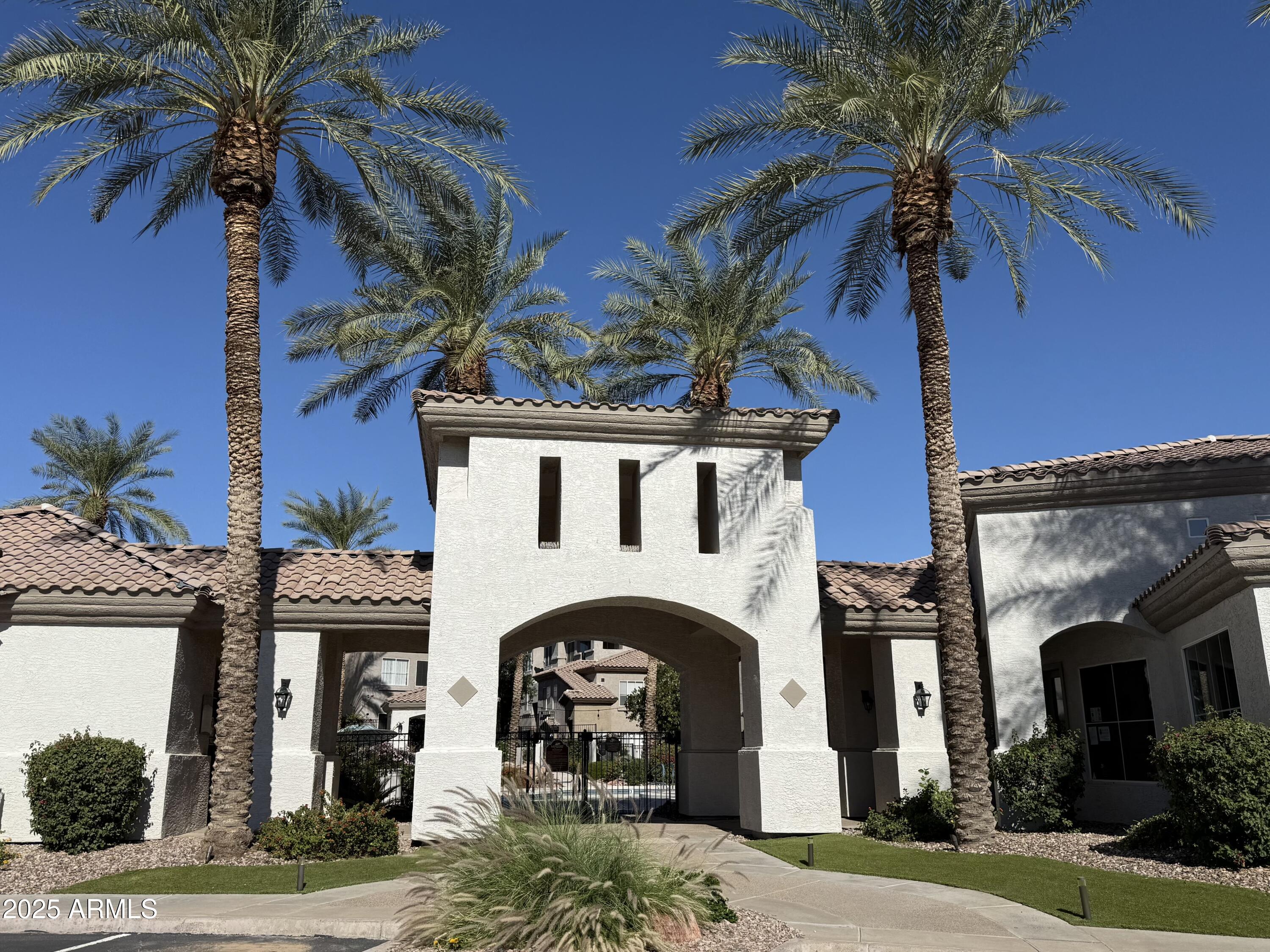 3236 East Chandler Boulevard, Unit 1071 Phoenix, AZ 85048 - Photo 2 of 35 a front view of a house with a palm tree