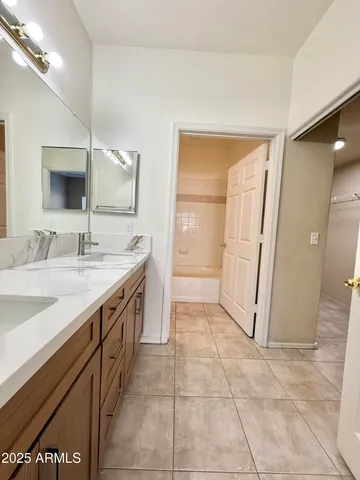 a spacious bathroom with a granite countertop sink a mirror and a vanity