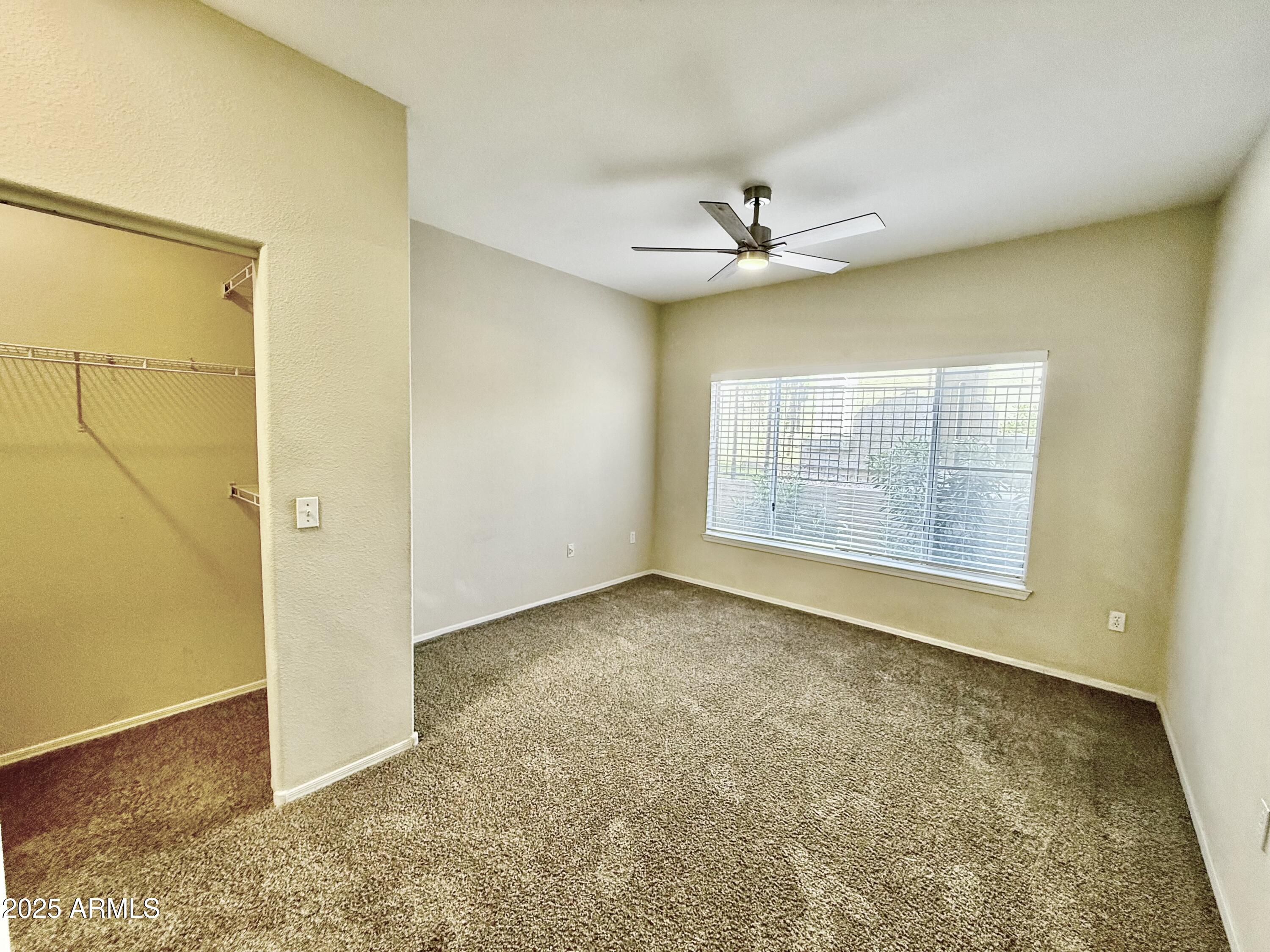 3236 East Chandler Boulevard, Unit 1071 Phoenix, AZ 85048 - Photo 27 of 35 an empty room with a empty space and a ceiling fan
