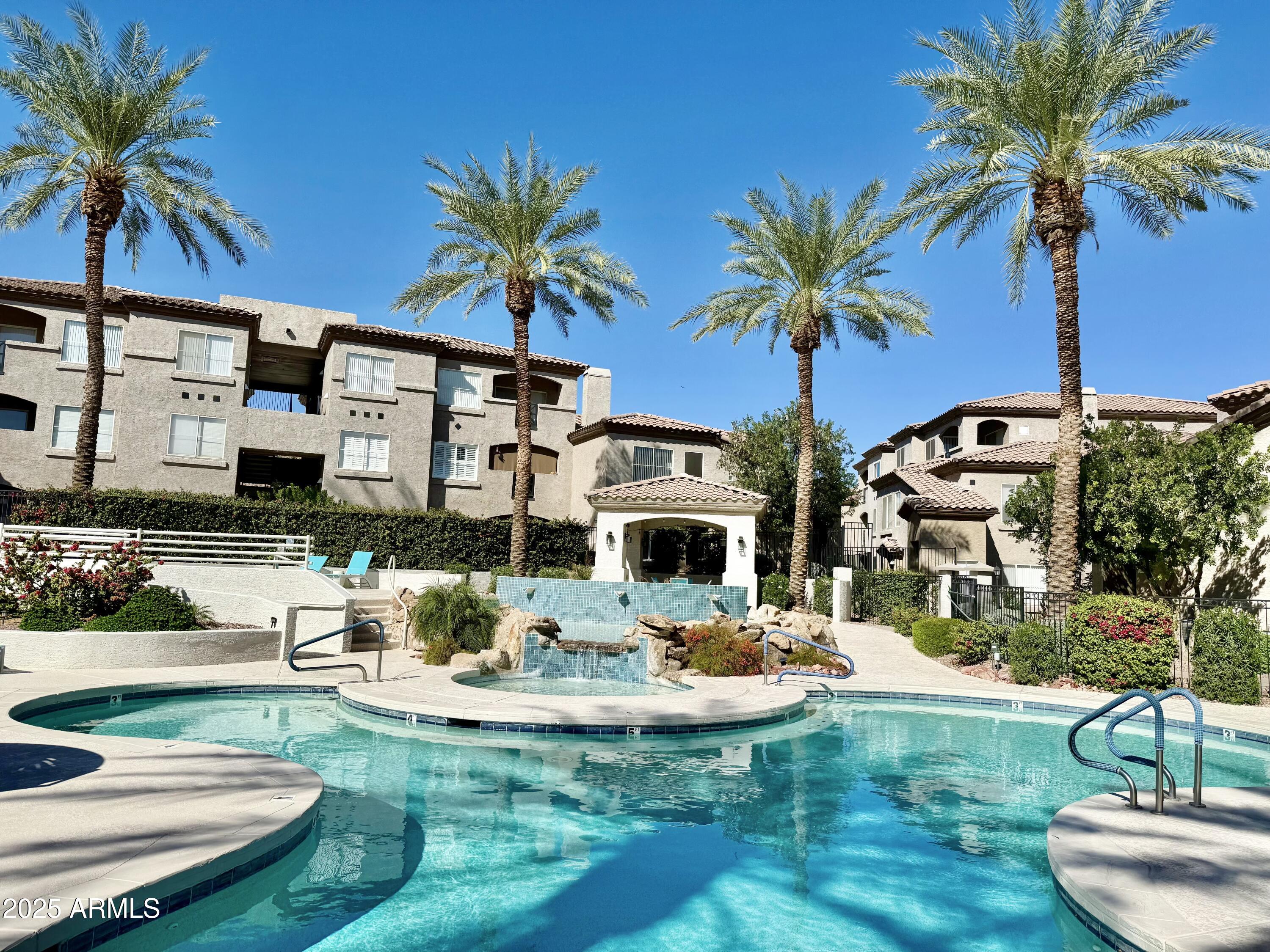 3236 East Chandler Boulevard, Unit 1071 Phoenix, AZ 85048 - Photo 4 of 35 a view of a swimming pool with a table and chairs