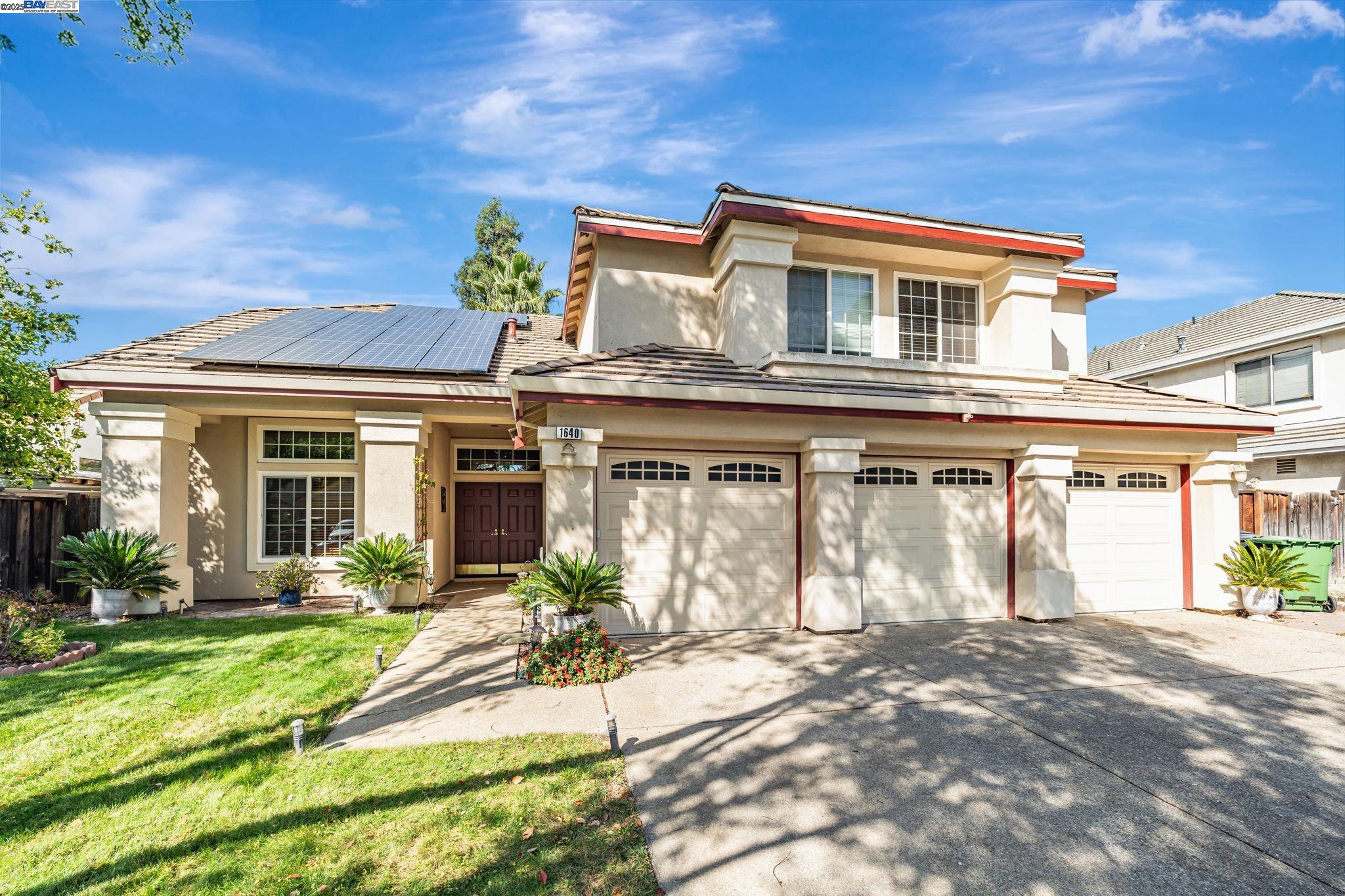 a front view of a house with a yard outdoor seating and garage