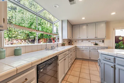 a kitchen with a sink window and cabinets