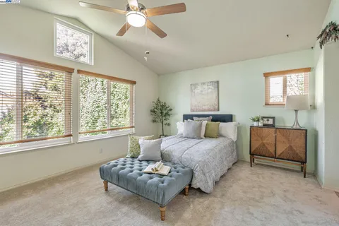 a bedroom with a bed mirror and window