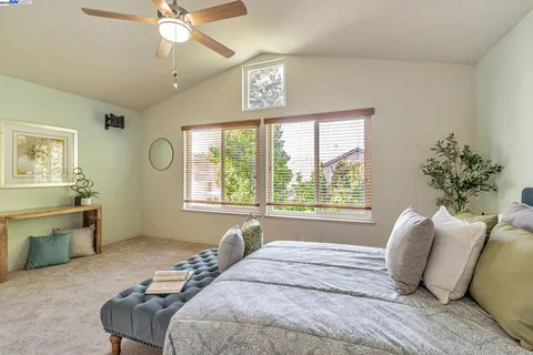 a bedroom with bed and a large window