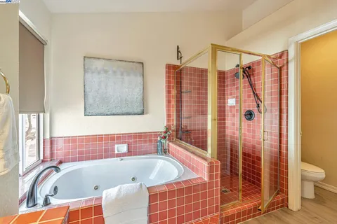 a bathroom with a tub a toilet and a shower