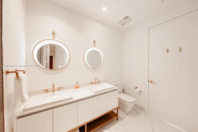 a en suite bathroom with a double vanity sink a mirror and shower