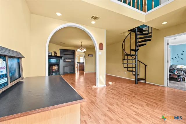 a view of a livingroom with a chandelier fan and windows