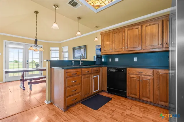 a kitchen with stainless steel appliances granite countertop a refrigerator a stove and a sink with wooden floor