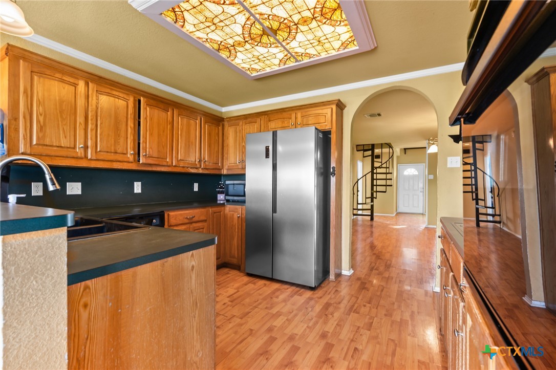 411 Wade Road Eddy, TX 76524 - Photo 41 of 48 a kitchen with stainless steel appliances granite countertop a refrigerator a stove and a sink with wooden floor