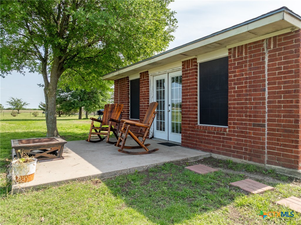 411 Wade Road Eddy, TX 76524 - Photo 46 of 48 a view of a backyard with chairs potted plants and a large tree