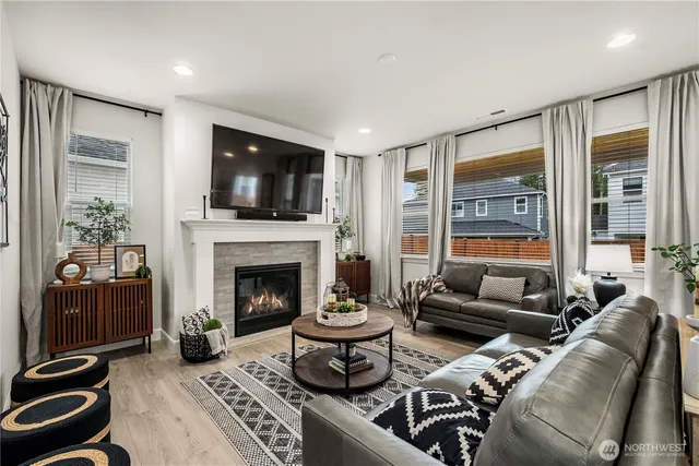 a living room with furniture a flat screen tv and a fireplace
