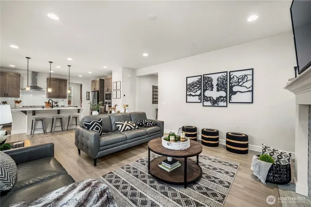 a living room with furniture and a view of kitchen