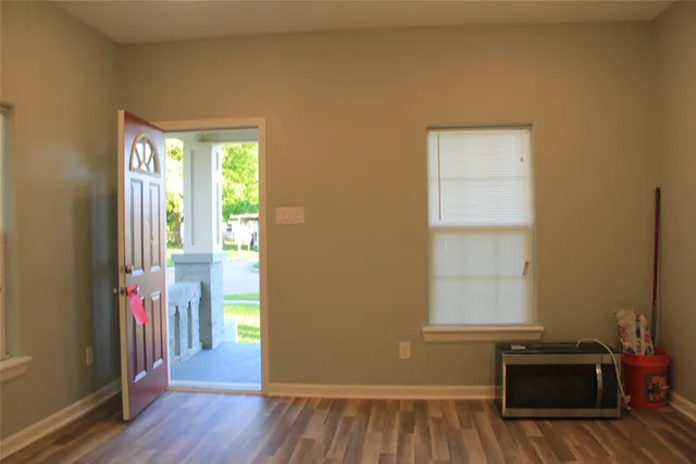 a view of a livingroom with wooden floor and a window