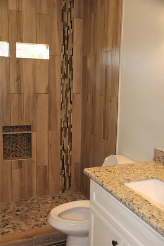 a bathroom with a granite countertop sink and a mirror