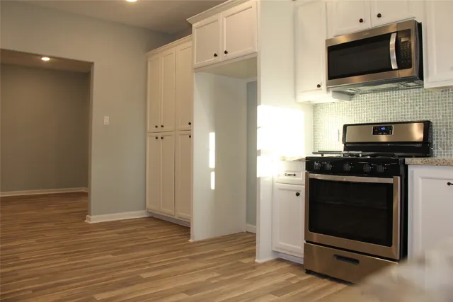 a kitchen with white cabinets and stainless steel appliances