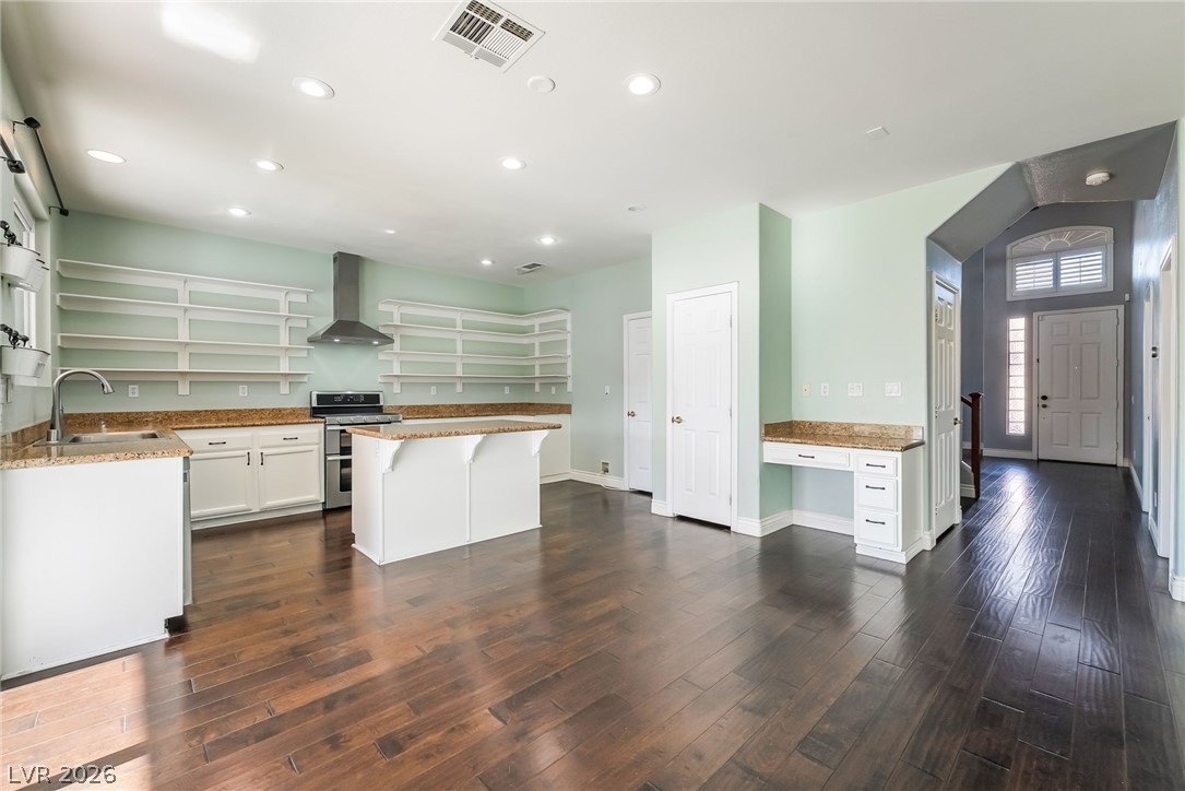 261 Timber Hollow Street Henderson, NV 89012 - Photo 13 of 51 Rich hardwood floors flow through this open-concept kitchen, featuring ample counter space and an integrated range hood.