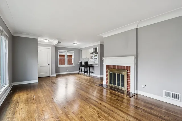 a view of a livingroom with wooden floor and a fireplace