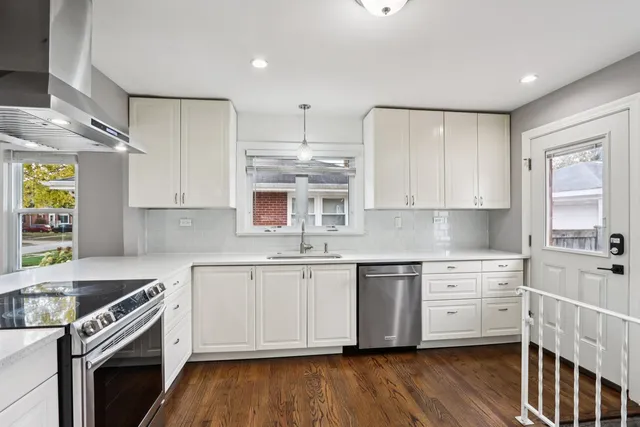 a kitchen with stainless steel appliances granite countertop a sink stove and cabinets