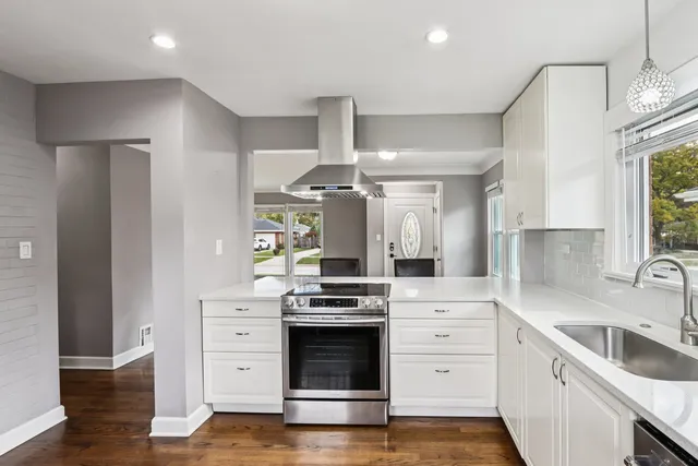 a kitchen with white cabinets and stainless steel appliances