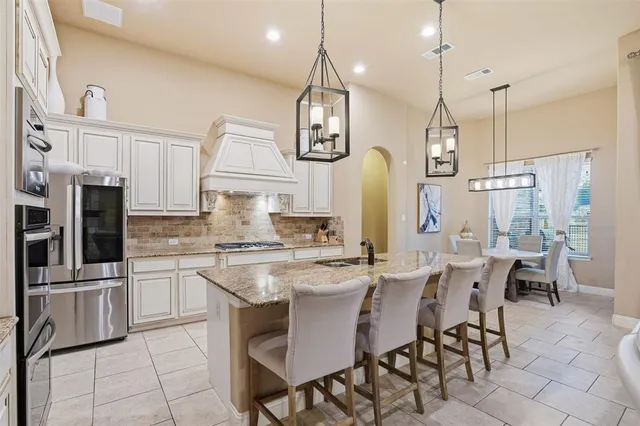 a kitchen with stainless steel appliances a stove center island refrigerator and cabinets