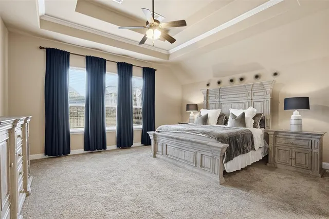 a spacious bedroom with a large bed and a chandelier