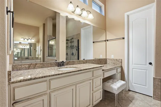 a bathroom with a granite countertop sink a toilet and mirror