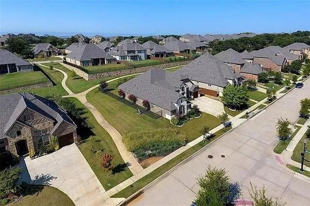 an aerial view of a house with a garden and lake view
