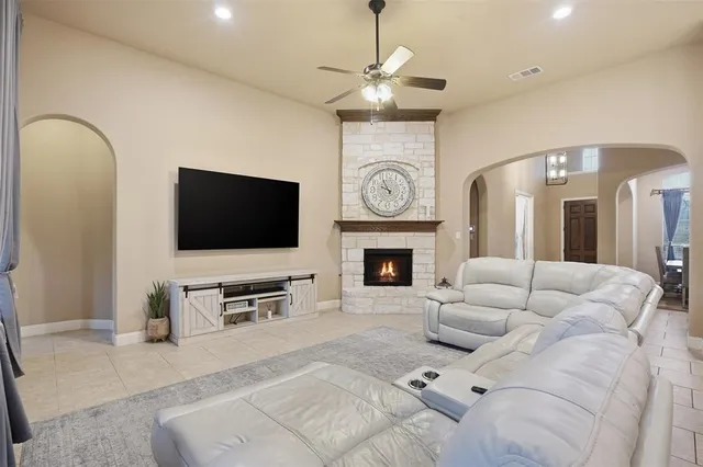a living room with furniture a flat screen tv and a fireplace