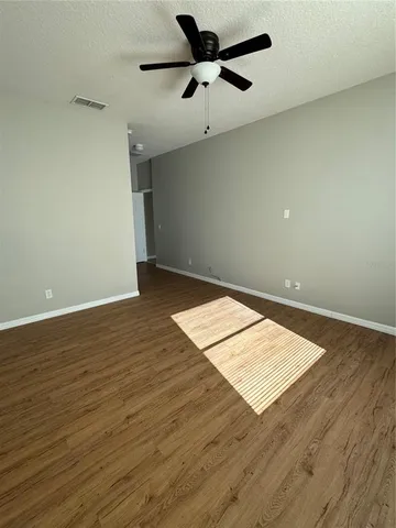 an empty room with a fan and a ceiling fan