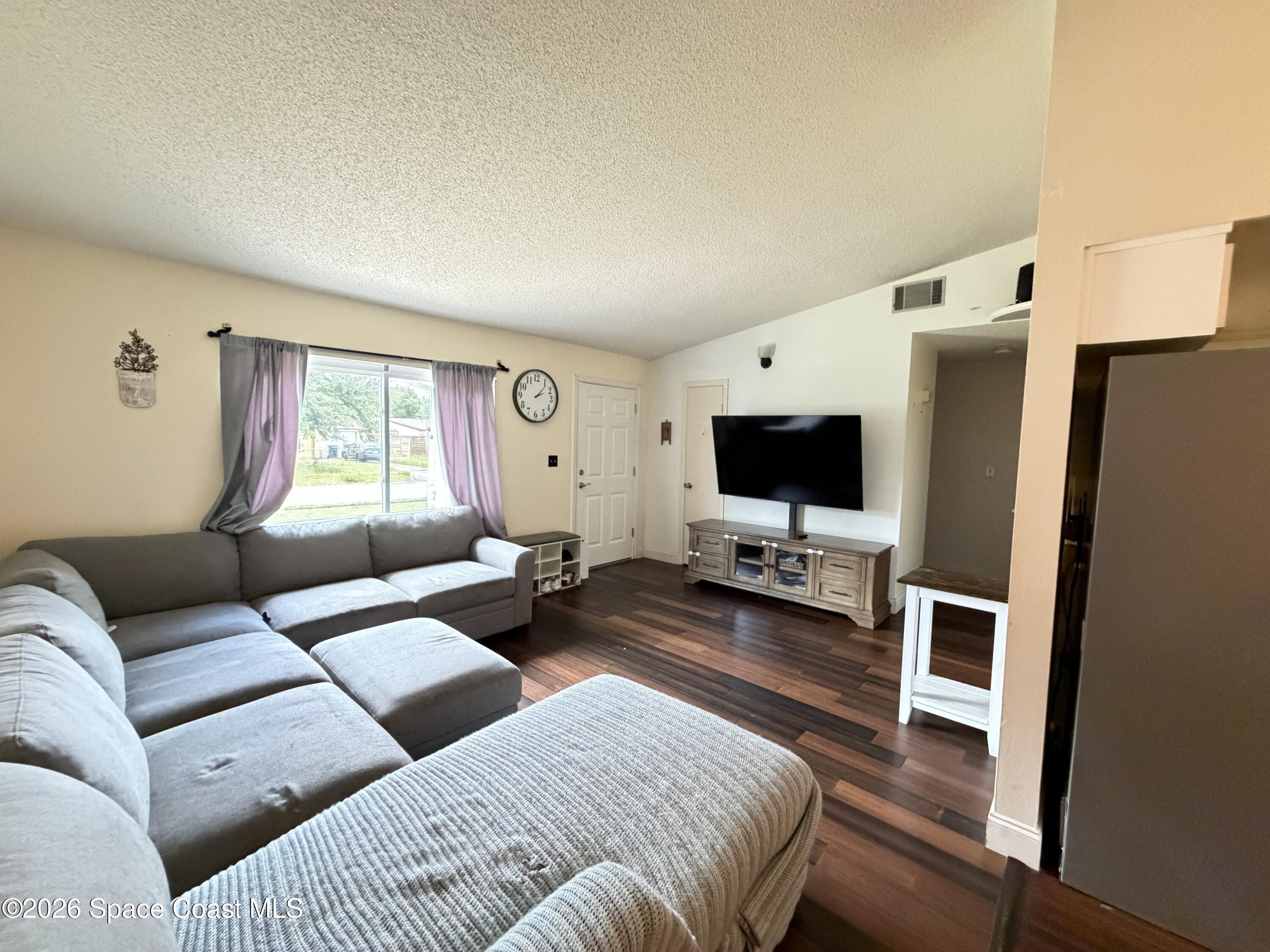 1578 West Powder Horn Road Titusville, FL 32796 - Photo 7 of 22 a living room with furniture and a flat screen tv