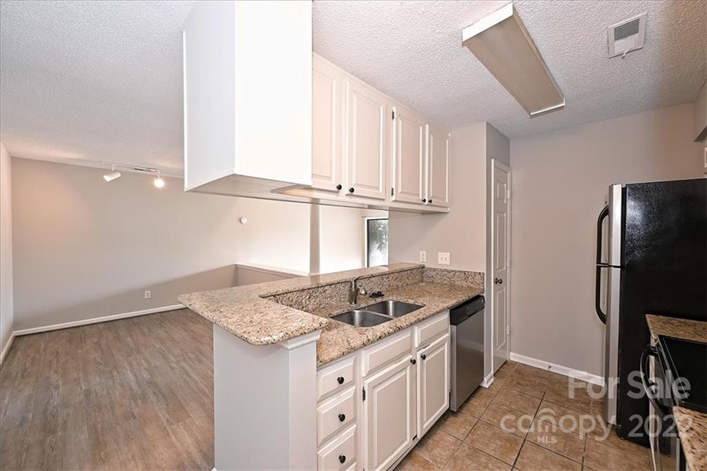 226 Queens Road, Unit 78 Charlotte, NC 28204 - Photo 12 of 32 a kitchen with stainless steel appliances granite countertop a stove a refrigerator and a sink