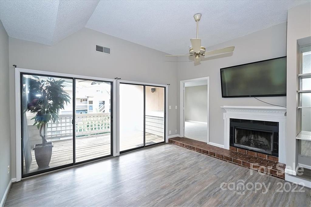 226 Queens Road, Unit 78 Charlotte, NC 28204 - Photo 15 of 32 an empty room with fireplace flat screen tv and windows
