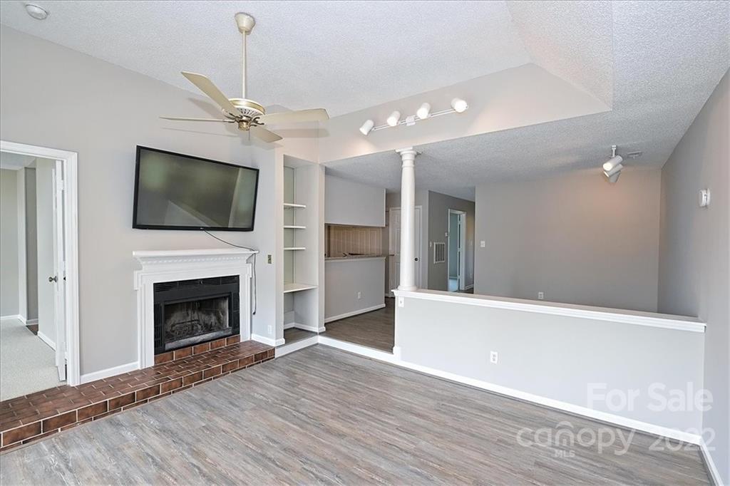 226 Queens Road, Unit 78 Charlotte, NC 28204 - Photo 17 of 32 a view of a livingroom with a fireplace a ceiling fan and wooden floor