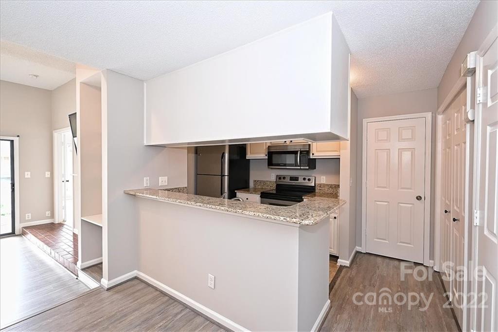 226 Queens Road, Unit 78 Charlotte, NC 28204 - Photo 10 of 32 a kitchen with stainless steel appliances granite countertop a refrigerator a sink and a stove