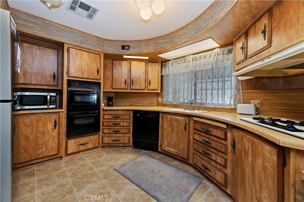 1630 Sonora Drive Hemet, CA 92543 - Photo 8 of 22 a kitchen with wooden cabinets and a stove top oven