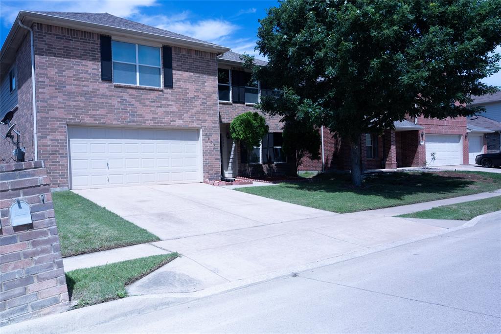8805 Graywolf Ridge Trail Fort Worth, TX 76244 - Photo 3 of 23 Brick exterior with a prominent two-car garage, concrete driveway, and established front landscaping