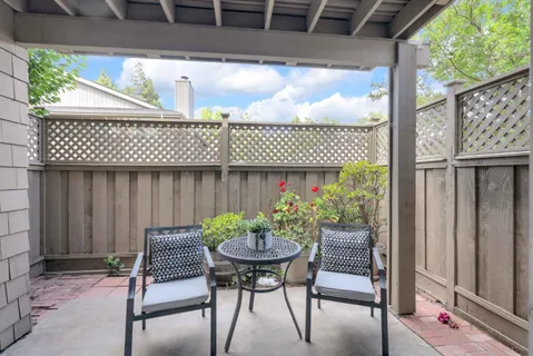 a view of a chairs and table in back yard of the house