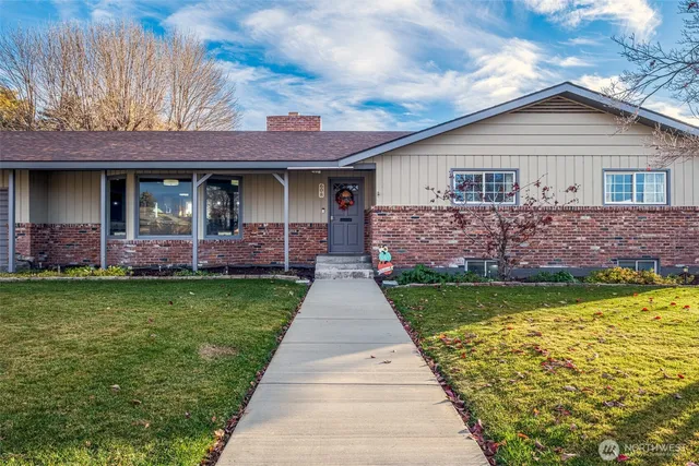 a front view of a house with a garden and plants