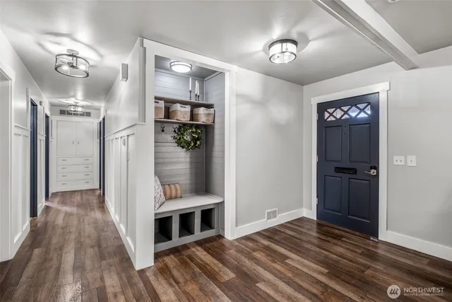 a view of a hallway with wooden floor and closet