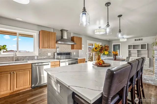 a dining table with chairs and kitchen view