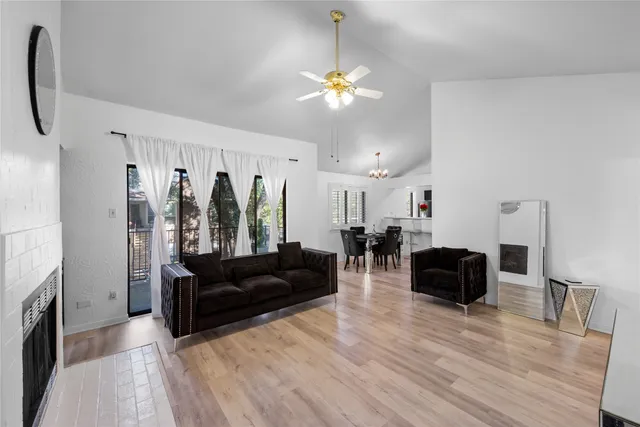 a living room with furniture a fireplace and a chandelier