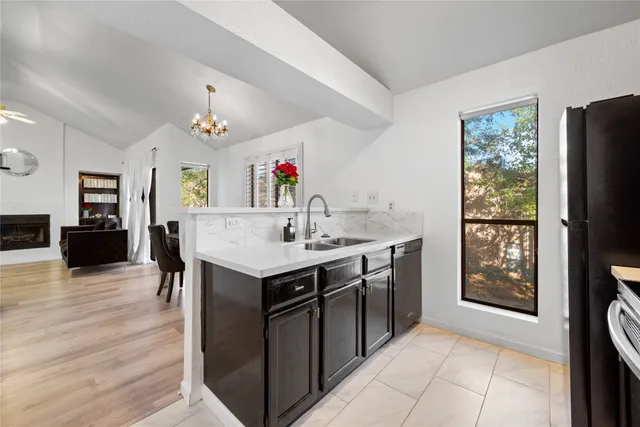 a view of kitchen island sink refrigerator and window