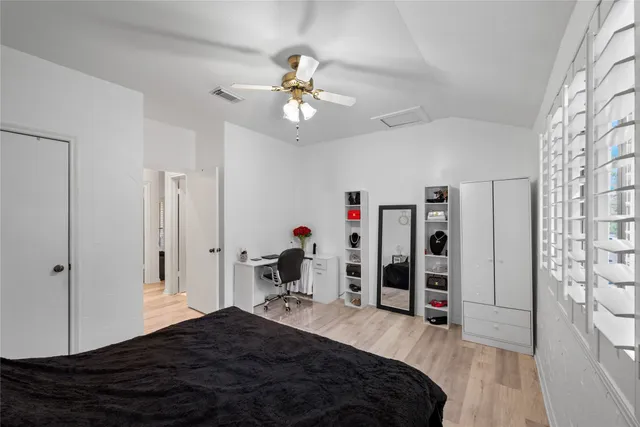 a bedroom with a bed chandelier and a window