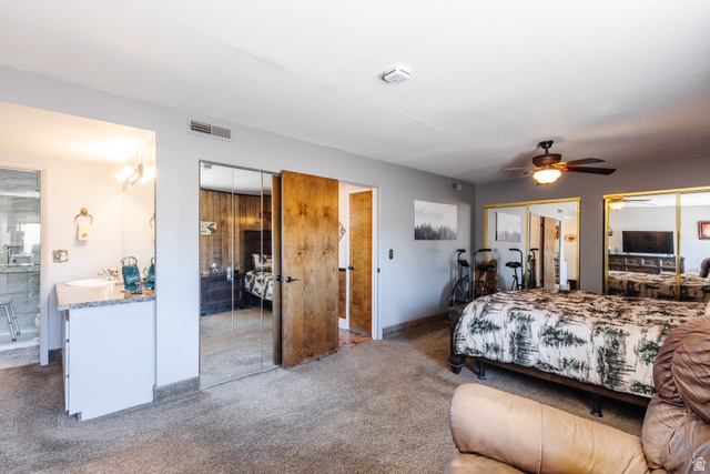 1470 Redwood Tree Street St. George, UT 84790 - Photo 15 of 53 Spacious room featuring neutral carpeting, a ceiling fan with integrated lighting, and multiple mirrored closet doors