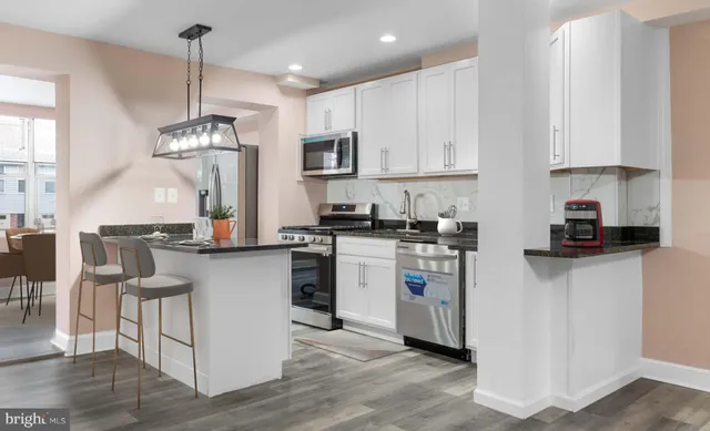 a kitchen with white cabinets and stainless steel appliances