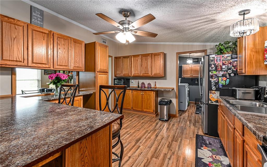 307 Hungarian Road Slippery Rock, PA 16057 - Photo 10 of 34 a kitchen with stainless steel appliances granite countertop a stove refrigerator and a dining table with wooden floor